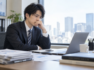 仕事を辞めたいと悩み、オフィスで将来の働き方を考える男性会社員
