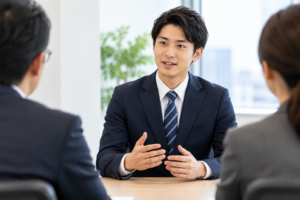 転職面接で採用担当者に向かって自己紹介をするスーツ姿の男性