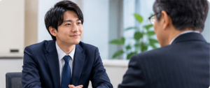 会社の会議室で直属の上司に退職の意思を伝える男性会社員の面談風景
